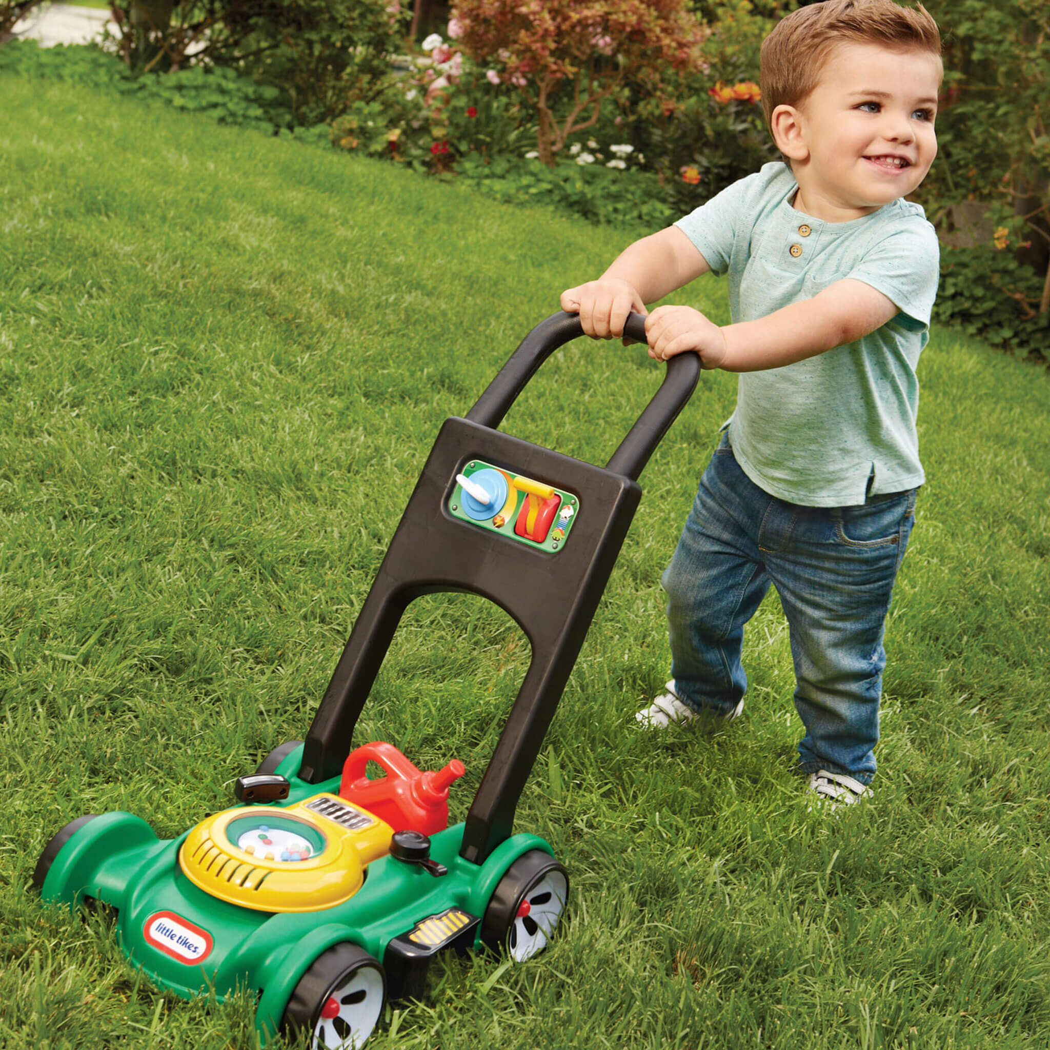 child pushing toy lawn mower